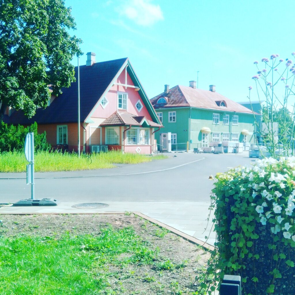 Pastel-coloured wooden houses in the centre of Kärdla under a bright blue summer sky.